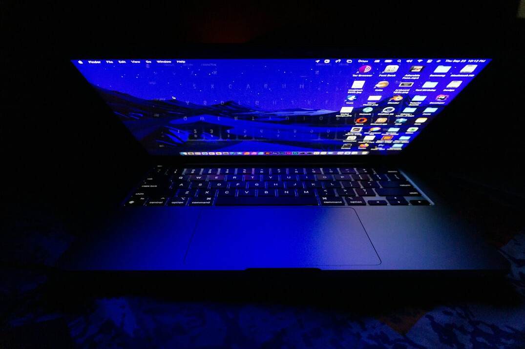 Laptop screen displaying a dark themed code editor with colorful syntax highlighting