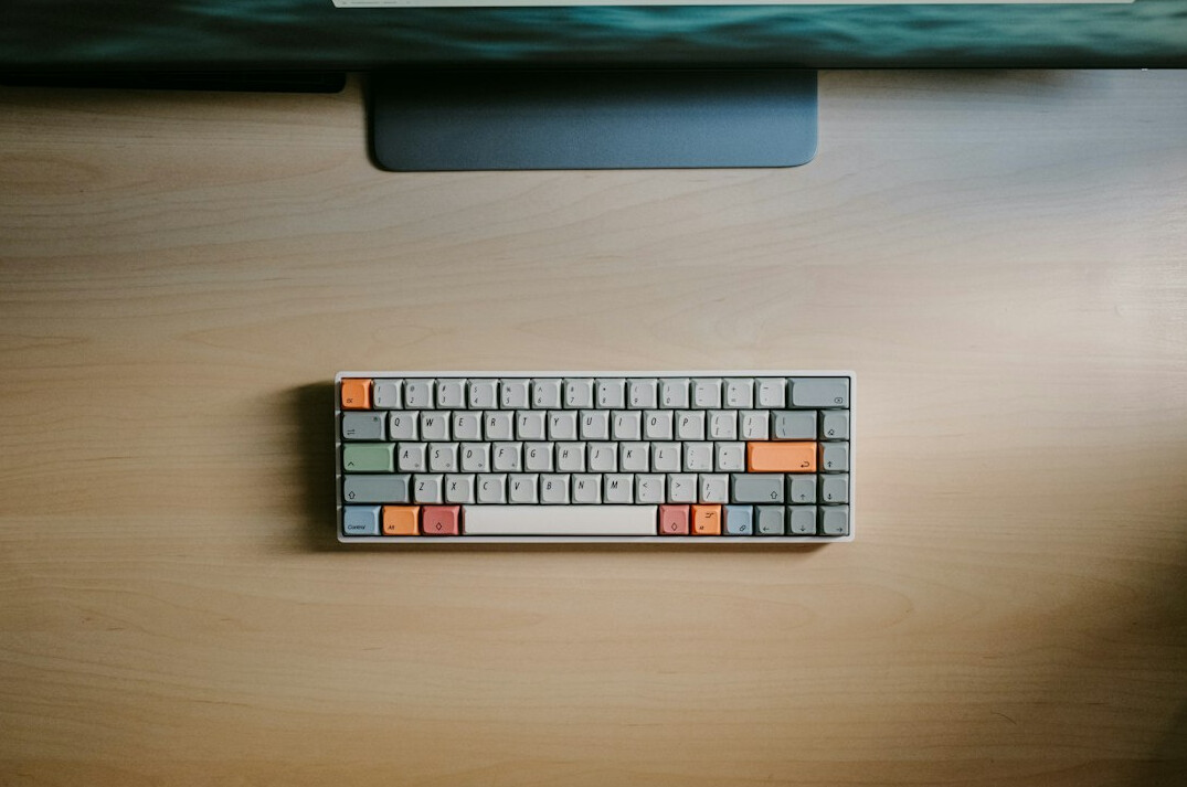 Croatian developer typing code on a laptop at a bright home desk