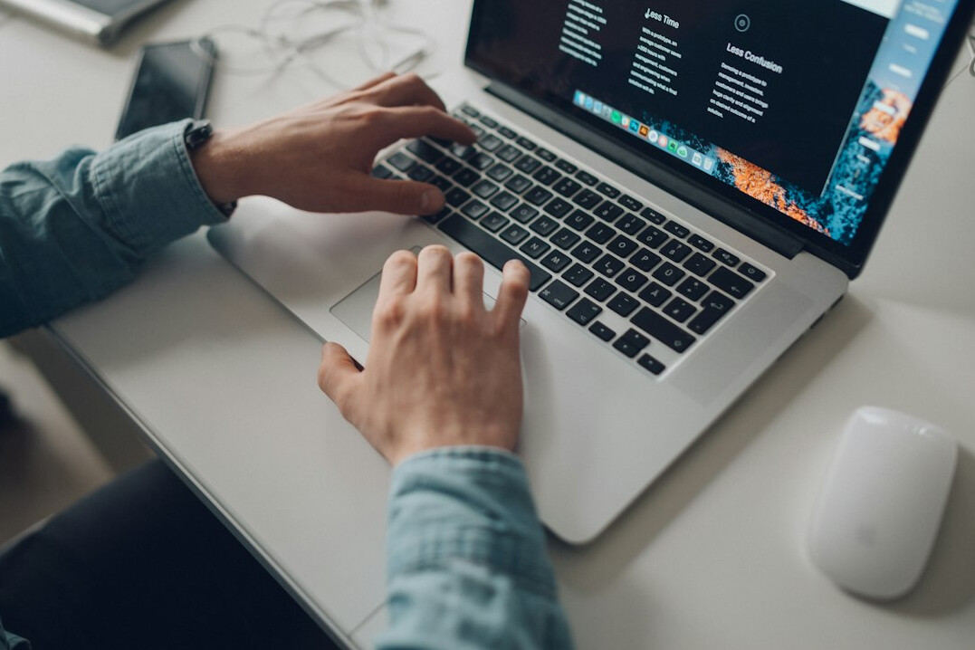 person coding on laptop